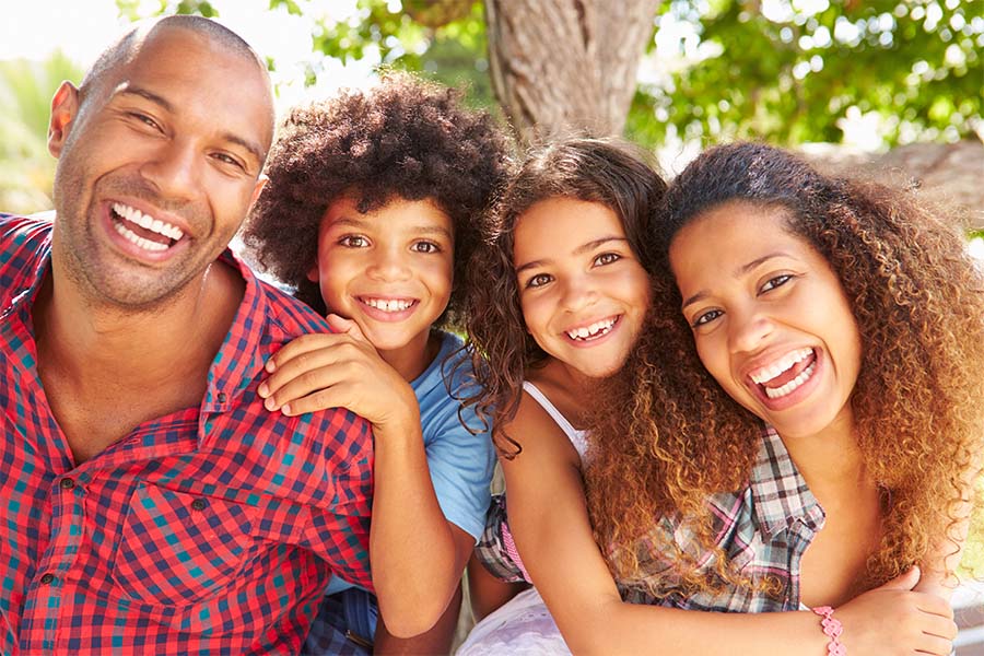 About Our Agency - Portrait Of Smiling Family With Two Kids Standing Outside