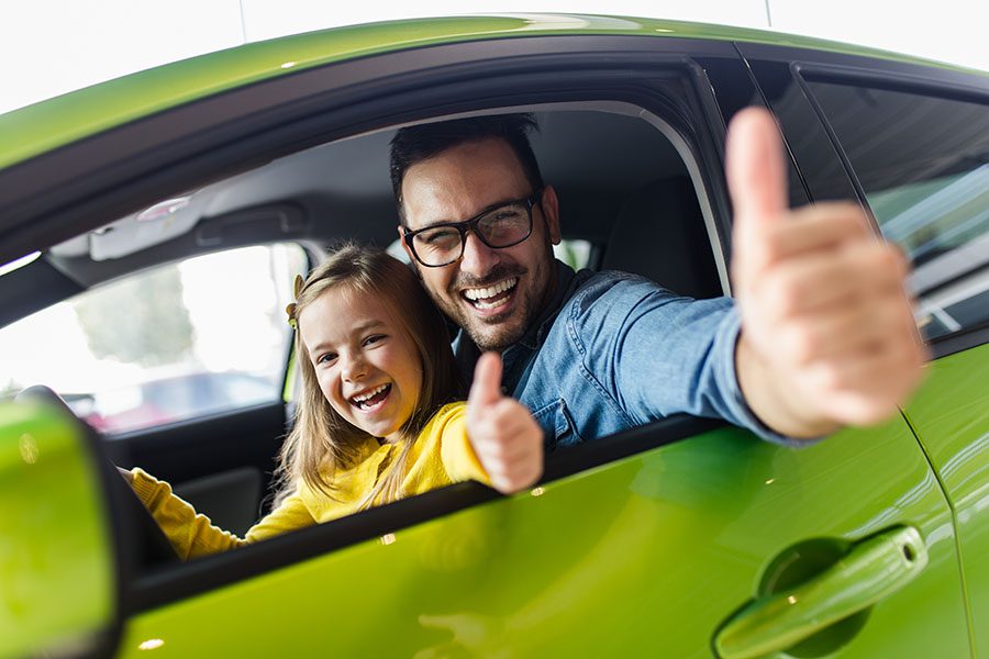 Contact - Smiling Father And Dauggter Sitting In Front Seat Of Car Give Thumbs Up